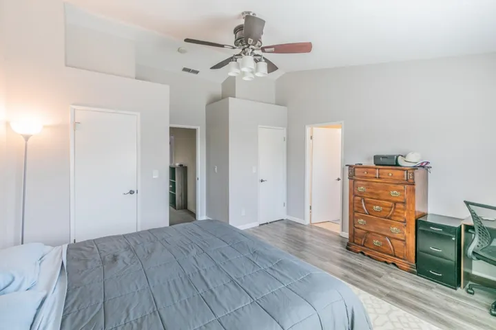 Bedroom featuring light wood-style flooring, a ceiling fan, and high vaulted ceiling
