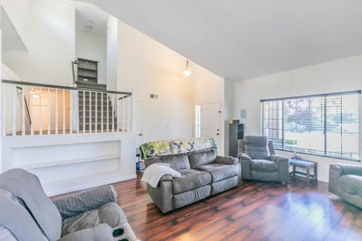 Living area featuring high vaulted ceiling and wood finished floors