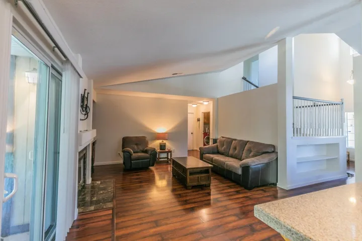 Living area featuring lofted ceiling, a fireplace, and dark wood finished floors