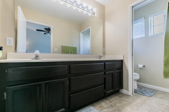 Bathroom with double vanity and light tile patterned flooring