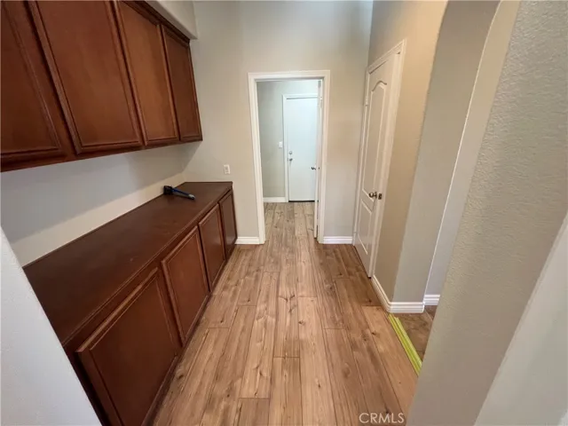 HALL WITH PLENTY OF STORAGE CABINETS LEADING TO THE LAUNDRY ROOM