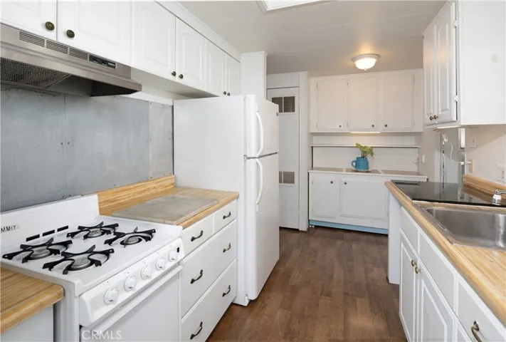 The cabinet with the blue flower pot has hook ups for a washer and dryer behind it if you wish to move the laundry area inside.