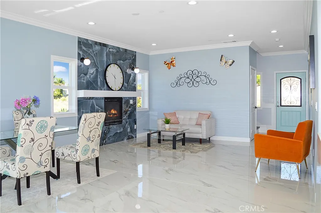 The open-concept great room offers you the flexibility to use the best how you desire and offers gorgeous tile flooring, crown moulding, recessed lighting and sliding doors open to the yard with a heatilator fireplace with modern tile surround, mantel, and sconces plus it is pre-wired for a TV (behind the clock).