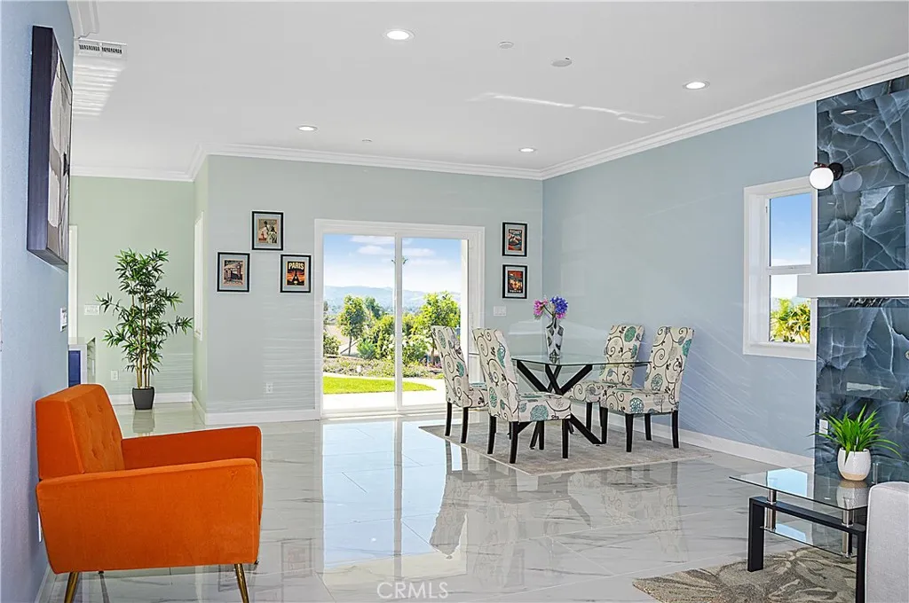 The open-concept great room offers you the flexibility to use the best how you desire and offers gorgeous tile flooring, crown moulding, recessed lighting and sliding doors open to the yard with a heatilator fireplace with modern tile surround, mantel, and sconces plus it is pre-wired for a TV (behind the clock).