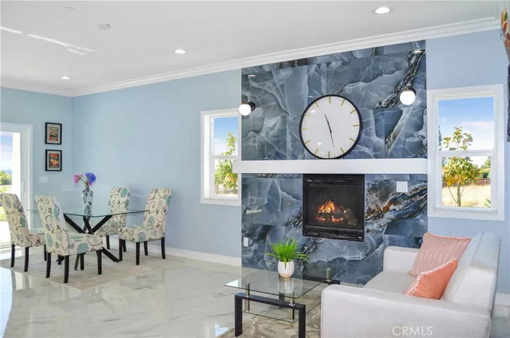 The open-concept great room offers you the flexibility to use the best how you desire and offers gorgeous tile flooring, crown moulding, recessed lighting and sliding doors open to the yard with a heatilator fireplace with modern tile surround, mantel, and sconces plus it is pre-wired for a TV (behind the clock).