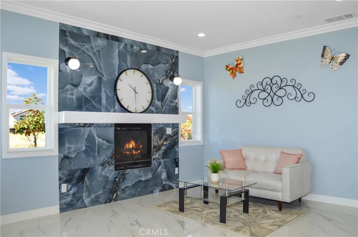 The open-concept great room offers you the flexibility to use the best how you desire and offers gorgeous tile flooring, crown moulding, recessed lighting and sliding doors open to the yard with a heatilator fireplace with modern tile surround, mantel, and sconces plus it is pre-wired for a TV (behind the clock).