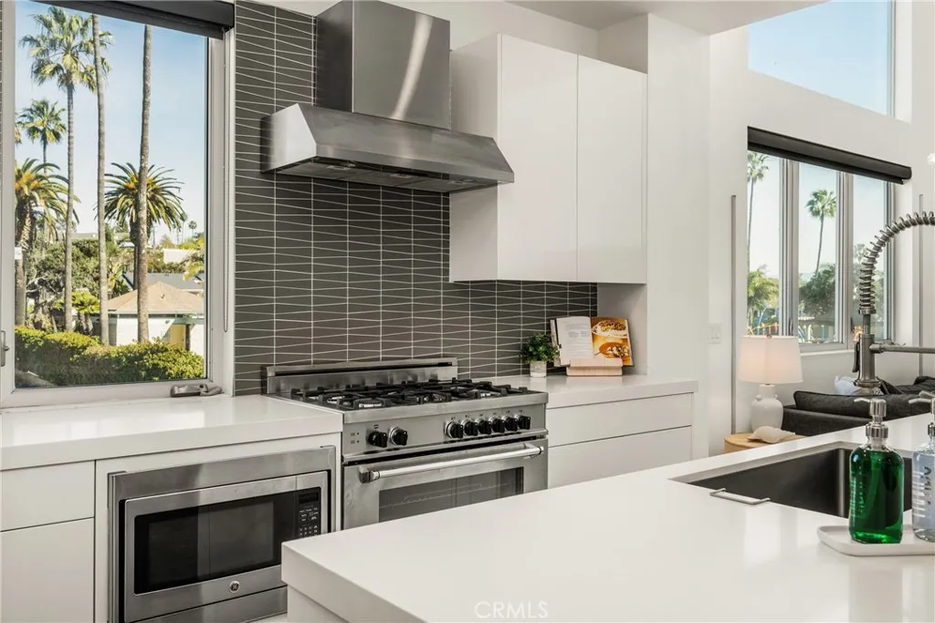 The chef’s kitchen is appointed with quartz countertops, a generous center island, modern European-style cabinetry, and premium stainless-steel appliances.