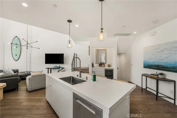 The chef’s kitchen is appointed with quartz countertops, a generous center island, modern European-style cabinetry, and premium stainless-steel appliances and opens to living area.