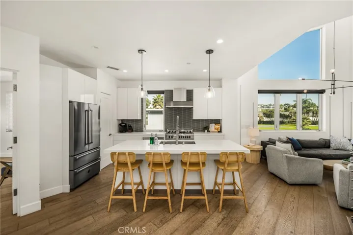 The chef’s kitchen is appointed with quartz countertops, a generous center island, modern European-style cabinetry, and premium stainless-steel appliances.