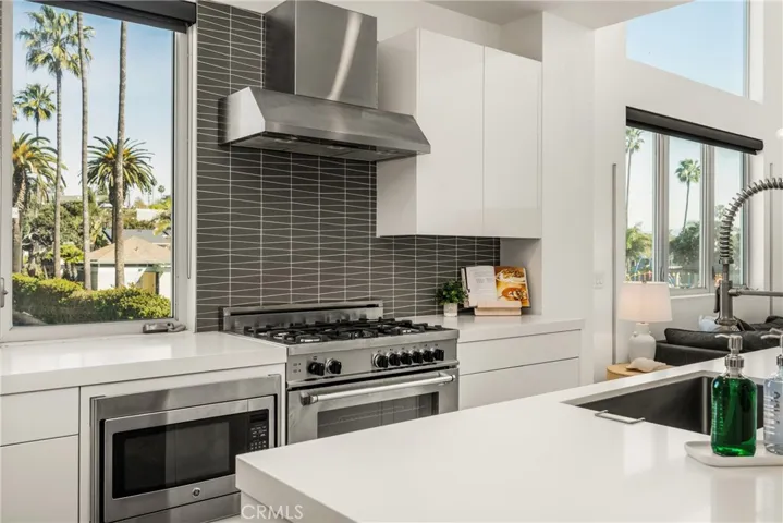 The chef’s kitchen is appointed with quartz countertops, a generous center island, modern European-style cabinetry, and premium stainless-steel appliances.