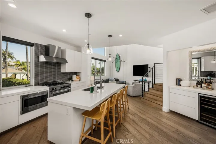 The chef’s kitchen is appointed with quartz countertops, a generous center island, modern European-style cabinetry, and premium stainless-steel appliances and opens to living area.