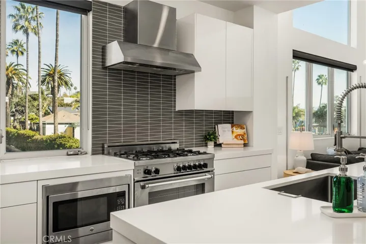 The chef’s kitchen is appointed with quartz countertops, a generous center island, modern European-style cabinetry, and premium stainless-steel appliances.