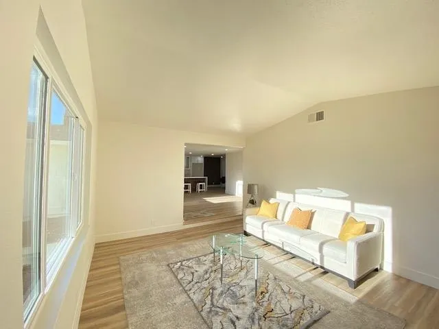 Living room with lofted ceiling and light wood-style floors