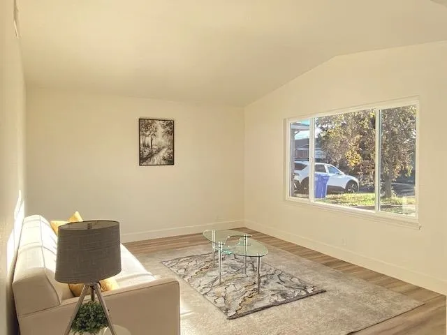 Sitting room featuring vaulted ceiling and light wood finished floors