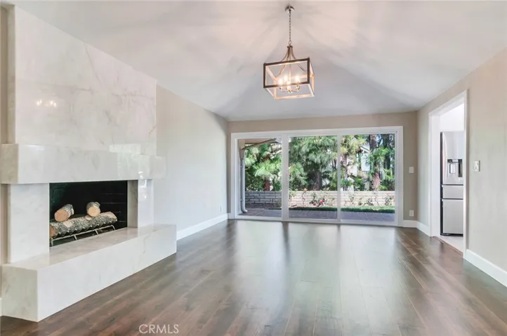 Family room with newer marble fireplace, newer wood floor and newer dual pane door.  Everything is new!