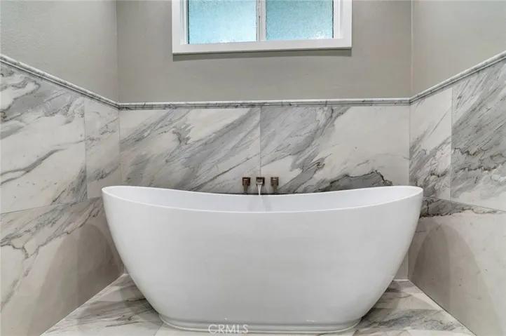 Tight shot of the soaking tub surrounded by marble