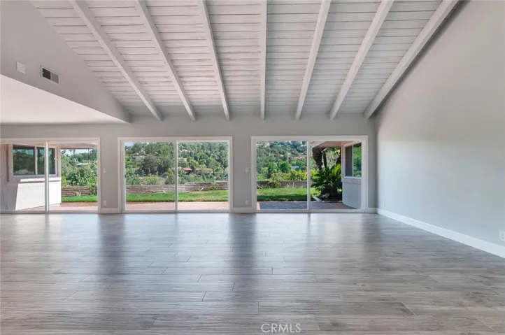 Living room with vaulted ceiling, newer tile flooring, newer dual pane sliding doors and a gorgeous view