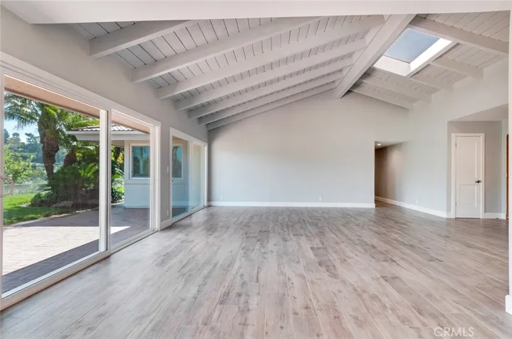 Living room looking from the dining room toward the hallway leading to the bedrooms.  Notice the skylight.