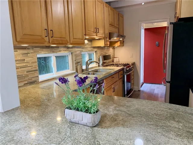 Breakfast bar, seating on both sides. Granite counters and glass backsplash.