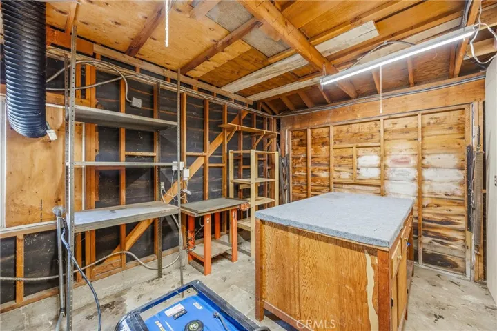 Second half of garage has work table and shelving