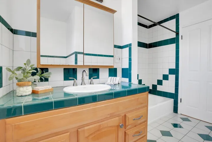 Bathroom with vanity, light tile patterned floors, and bathing tub / shower combination