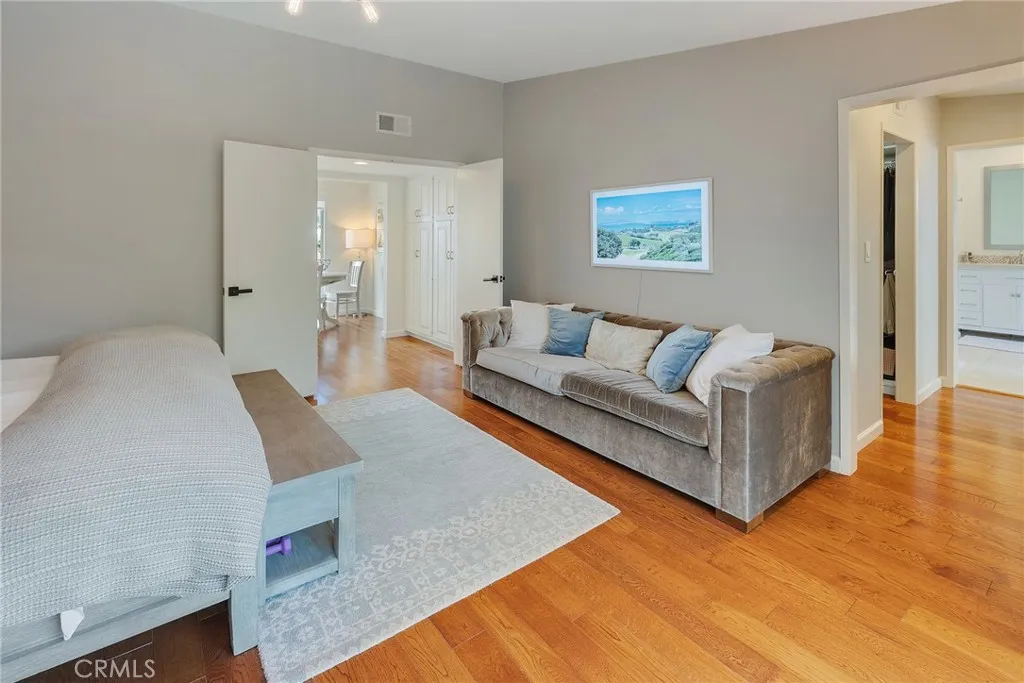 Another View of the primary Suite Showing connection to a hallway and closets on both sides.