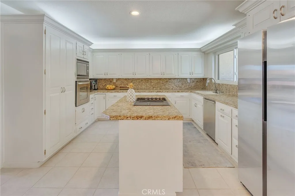 The Kitchen is Completely Remodeled with Granite Counter Tops, Center Island with Electric Cooktop, New Sink and Fixtures, Beautiful Cabinetry and Built in Storage. Newer Stainless Refrigerator and Dishwasher complete this modern look.