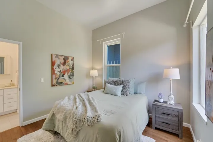 Bedroom with light wood-type flooring and ensuite bathroom