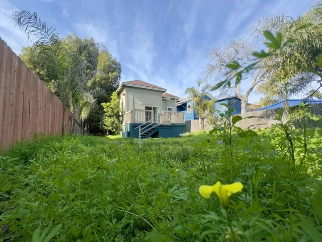 Back of property featuring a fenced backyard and a deck