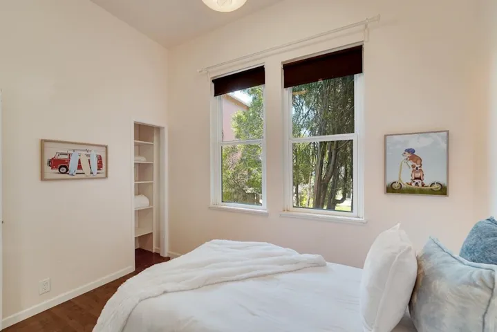 Bedroom featuring dark wood-type flooring and a walk in closet