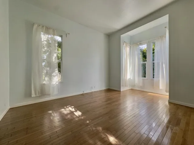 Unfurnished room featuring hardwood / wood-style flooring and baseboards