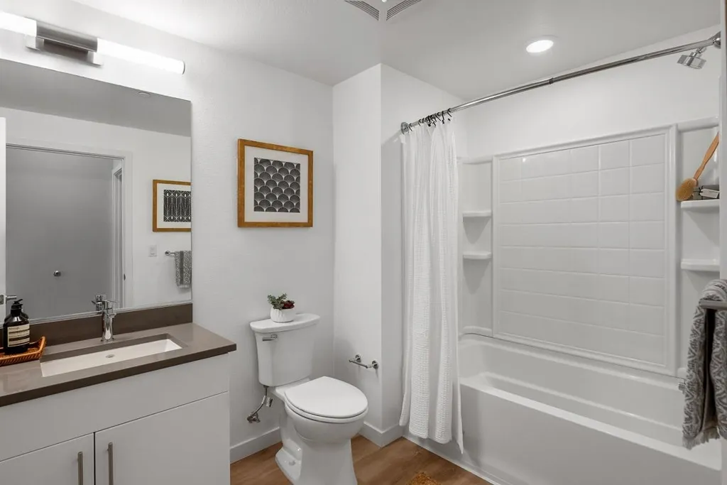 Bathroom featuring shower / bath combination with curtain, light wood finished floors, vanity, and recessed lighting