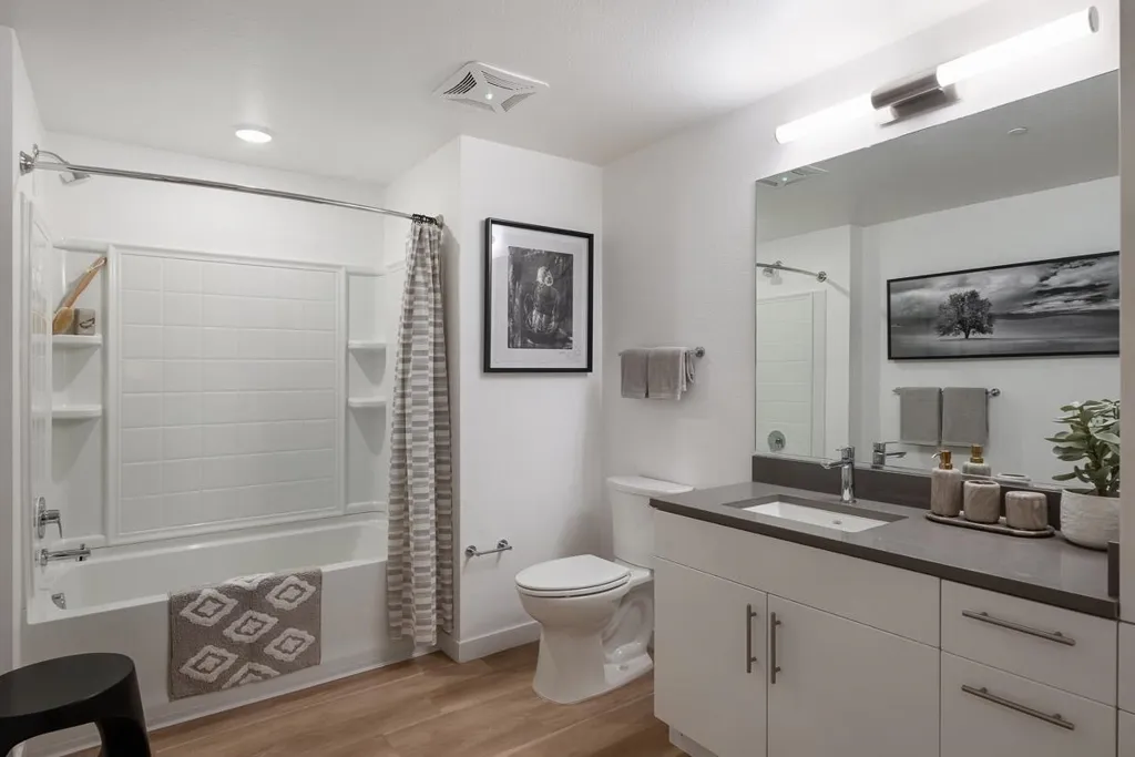 Full bathroom featuring shower / tub combo with curtain, light wood-style flooring, and vanity