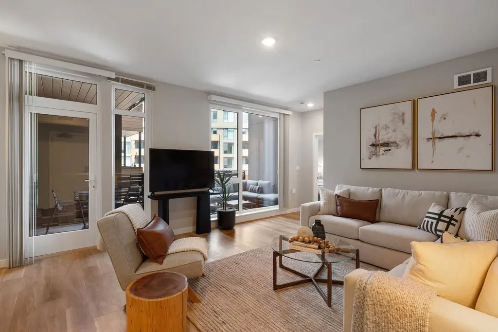 Living room with wood finished floors, recessed lighting, and floor to ceiling windows