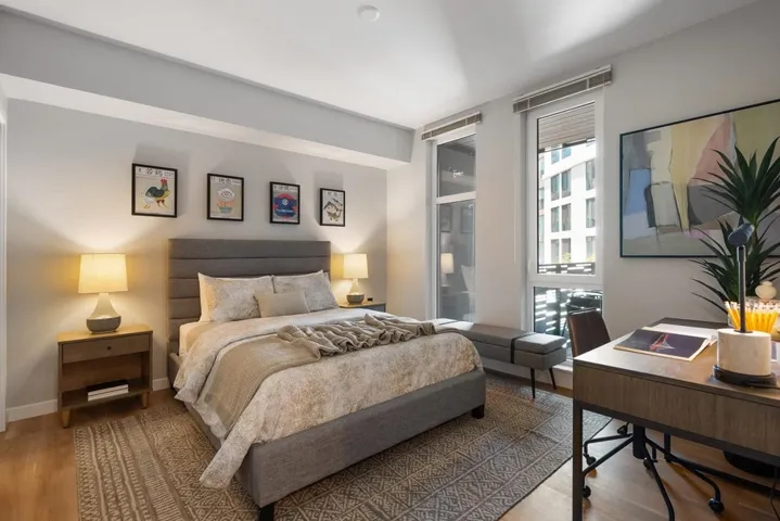 Bedroom featuring wood finished floors and an office area
