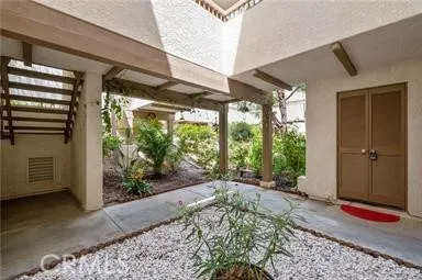 Ground-level view of the exterior stairs and an open walkway area leading to the front door.