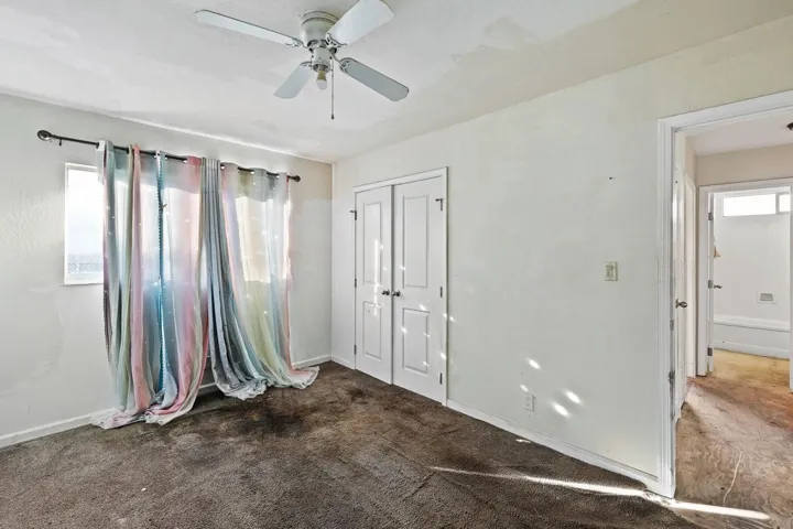 Unfurnished bedroom featuring a ceiling fan, a closet, and carpet floors