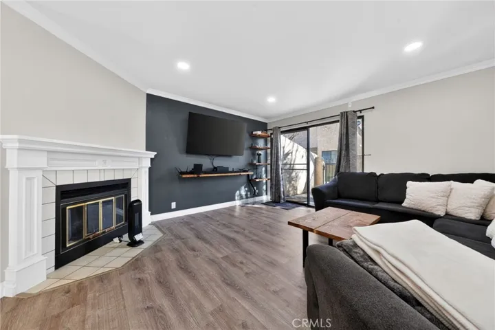 Cozy fireplace  adds to the ambiance of this welcoming room. Note crown molding.