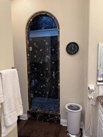 Arched shower doorway with dual shower heads.