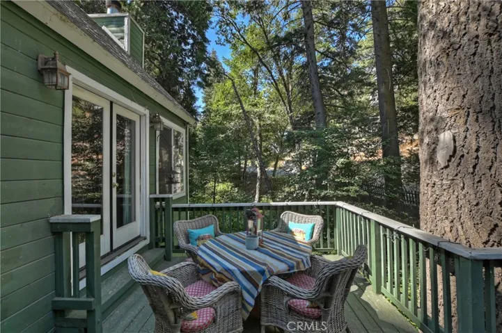 Outdoor patio nestled among mature trees and overlooking a seasonal creek, offering a peaceful and private setting for outdoor enjoyment.