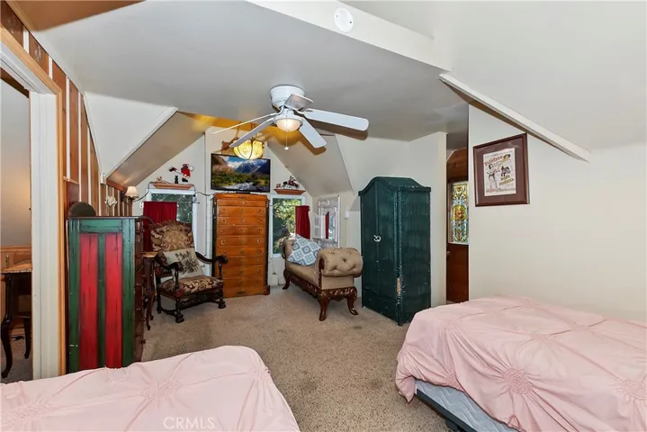Comfortable upstairs bedroom with space for two twin beds and an attached quarter bath, offering privacy and functionality for overnight guests.