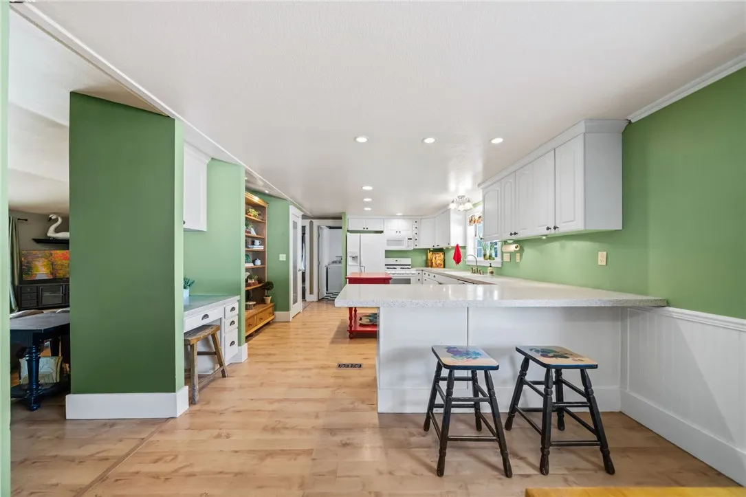 View from dining room area shows quartz counter has additional seating at the counter and a desk area