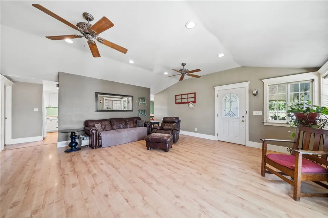 Living room with view of front door and kitchen behind the wall