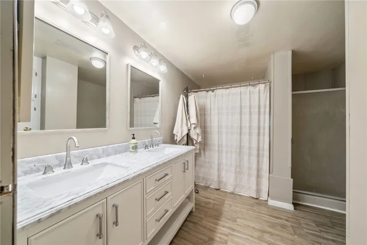Primary bathroom with new vanity, sinks, fixtures, mirrors and lighting