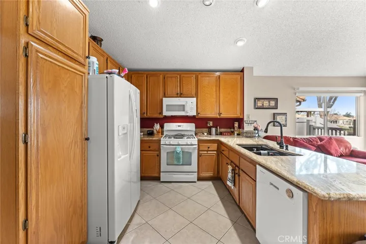 Wood Cabinets and White Appliances in Kitchen