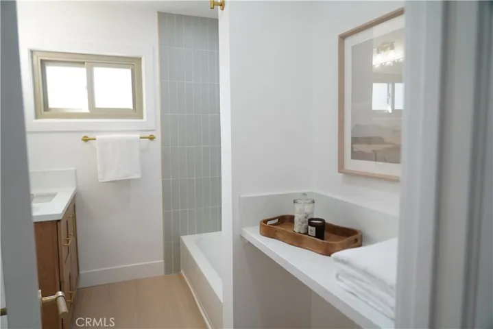 Guest bath with tub shower and powder seating area or storage space