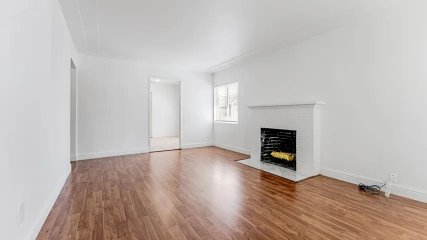 Living room featuring wood finished floors and a brick fireplace