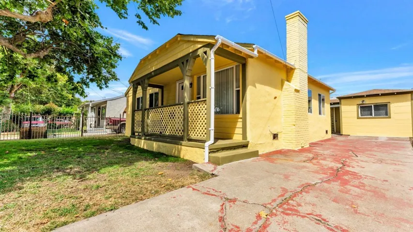 View of side of property with a chimney and covered porch