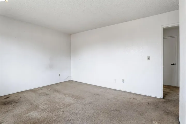 Carpeted spare room featuring a textured ceiling