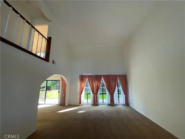 two-story ceiling in the living room accompanied by windows